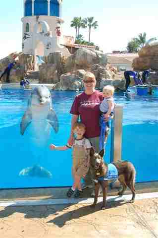 Sandy Mays and Hawk, of the Canine Angels service dogs, with family and unnamed Dolphin.
